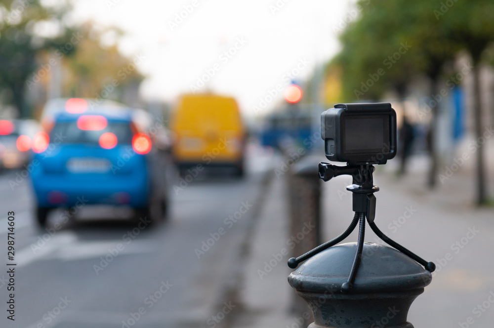 Fototapeta premium Action camera stands on a pole in the city (with beautiful bokeh)