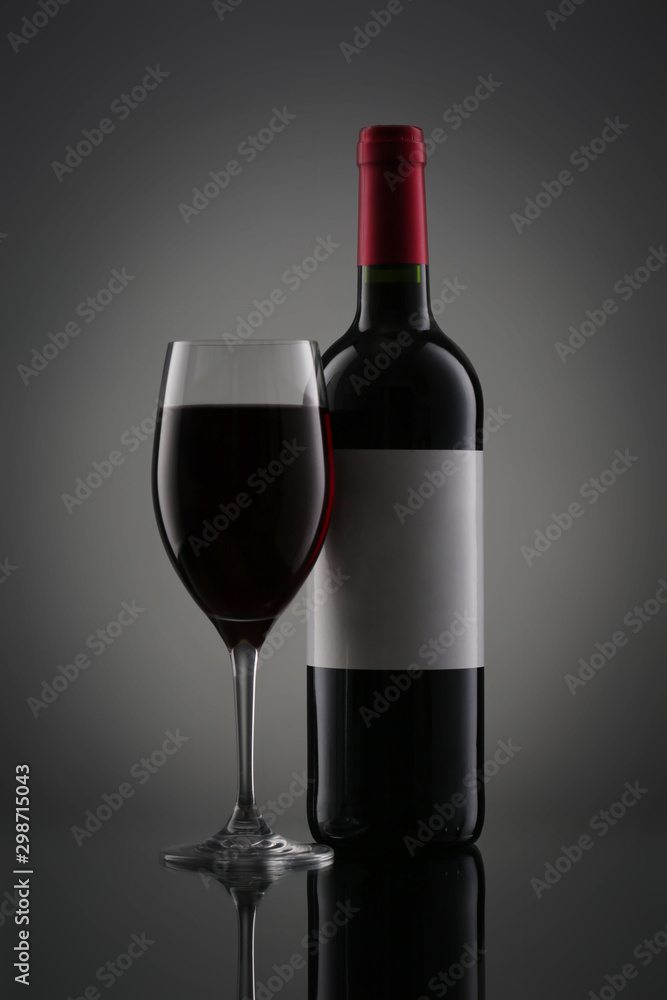 Bottle of red wine with label and wineglass on gradient background Bottle of red wine with label and wineglass on gradient background