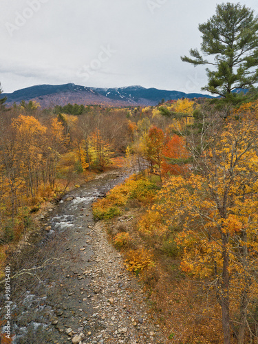 Aerial drone overhead image of a Vermont brook and stream with fall colors all around