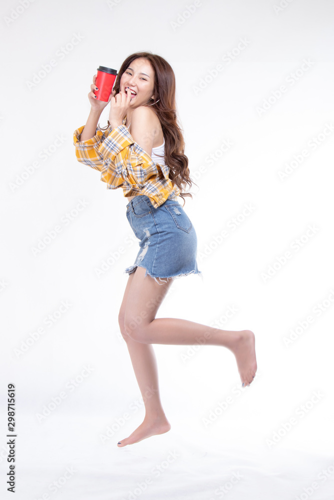 Obraz premium Portrait of attractive pretty lovely stylish nice cute cheerful a young asian woman wearing yellow shirt hand holding red coffee paper cup on white background.