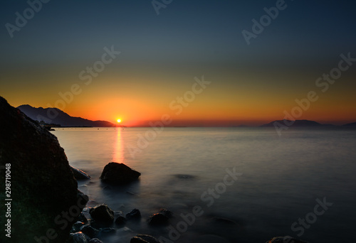 Panorama of beautiful sunrise at Kos. Stones in front of sunrise.