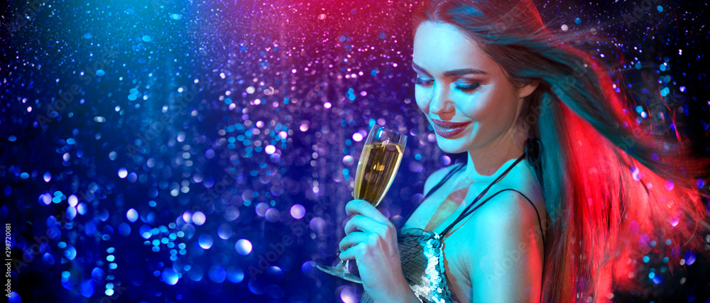Model girl with glass of champagne drinking and dancing at disco party, on holiday glowing blue with red background. Beauty woman, perfect fashion makeup. Christmas and New Year holiday celebration - obrazy, fototapety, plakaty 
