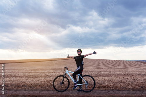 happy girl on a mountain bike in the evening field