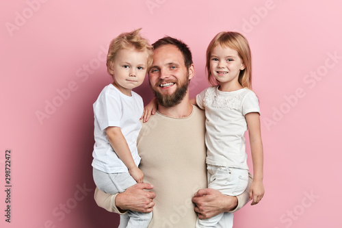 positive father having fun with children, close up portrait, isolated pink background, studio shot, leisure, pastime, people, good relation between father and kids