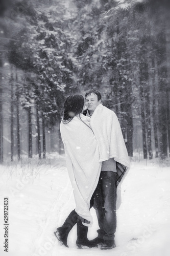 A loving couple on a winter walk. Man and woman on a date in the park in winter. Friends in a winter park © alexkich