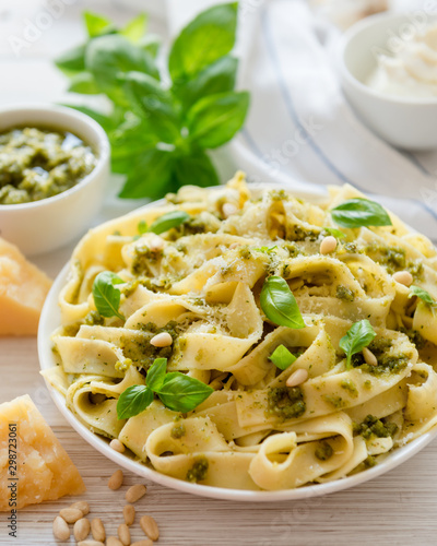 Large portion of noodles with fresh basil pesto and pine nuts