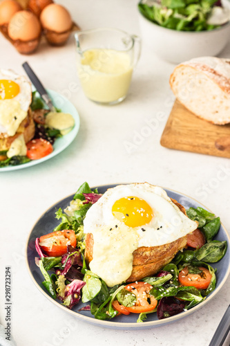 Croque Madame - hot french sandwich with ham, melted emmental cheese, fried egg and bechamel sauce with salad. Delicious breakfast. food, sandwich, cheese, breakfast, bread