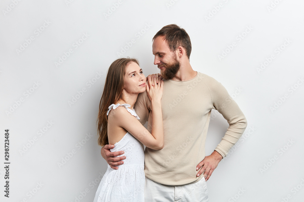 girl with long brown hair putting her arms on her guy's shoulder, relies on him, relationship between wife and husband , isolated white background