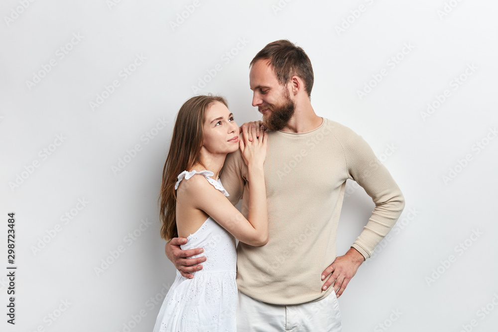 girl with long brown hair putting her arms on her guy's shoulder, relies on him, relationship between wife and husband , isolated white background girl with long brown hair putting her arms on her guy's shoulder, relies on him, relationship between wife and husband , isolated white background