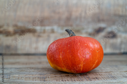 Orange pumpkins on a background of natural wood. Halloween decoration. Seasonal autumn products.