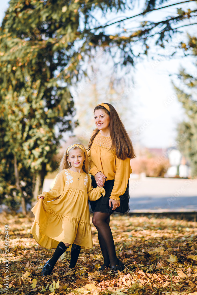 mom and little daughter have fun in autumn park