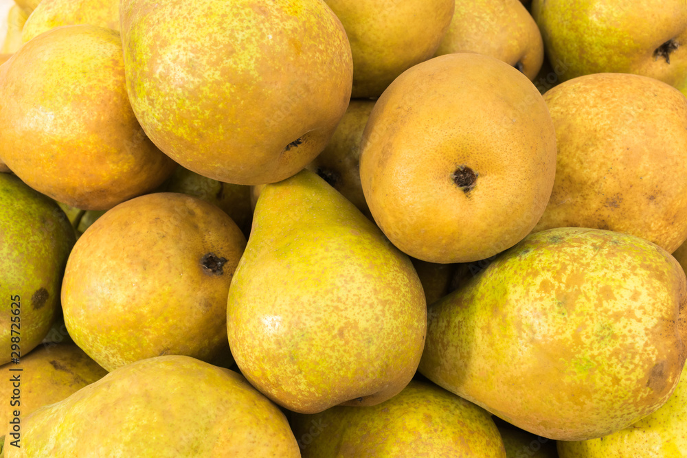 Yellow ripe pears lined up for sale in a supermarket
