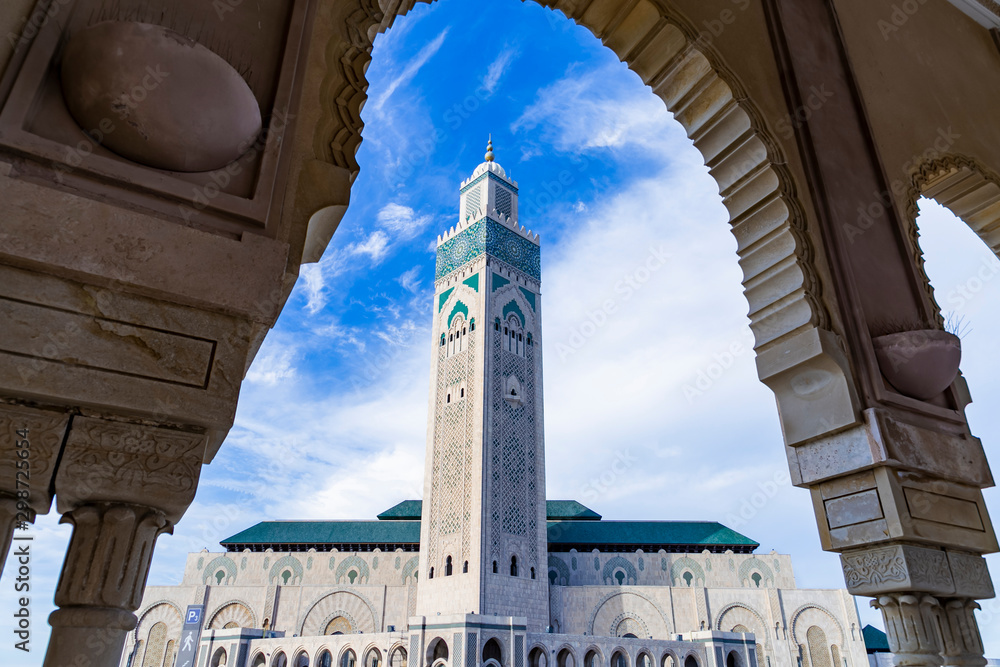 View of Hassan II mosque against blue sky - The Hassan II Mosque or Grande Mosquée Hassan II is a mosque in Casablanca, Morocco. - obrazy, fototapety, plakaty 