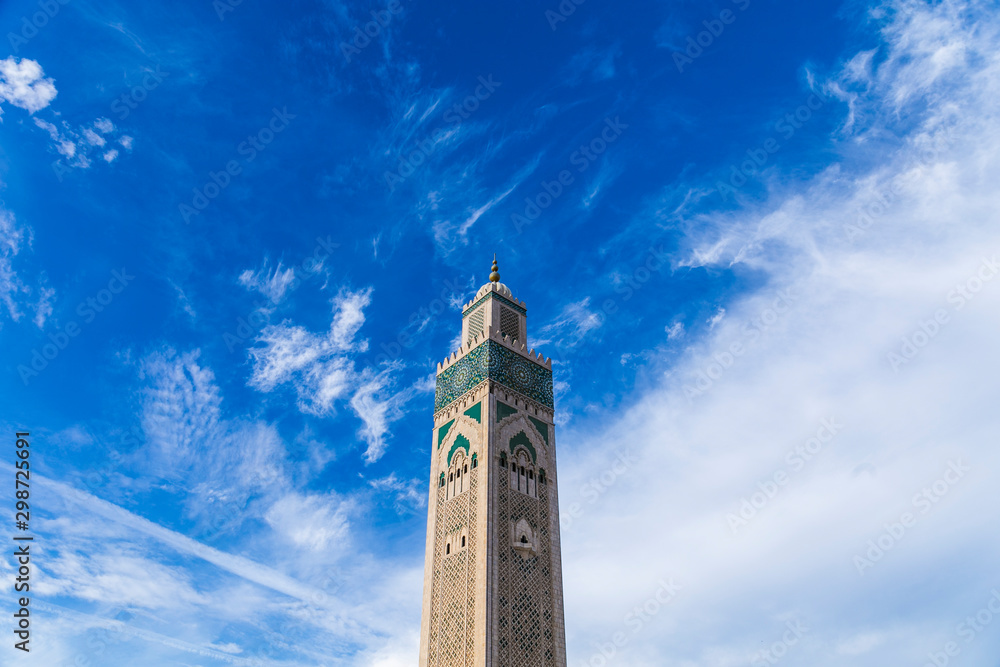 View of Hassan II mosque tower against blue sky - The Hassan II Mosque or Grande Mosquée Hassan II is a mosque in Casablanca, Morocco.