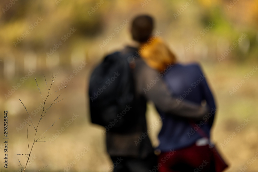 blur couple in love standing on a hill enjoying the beautiful view in autumn. Man hugging woman. Back view blur couple in love standing on a hill enjoying the beautiful view in autumn. Man hugging woman. Back view