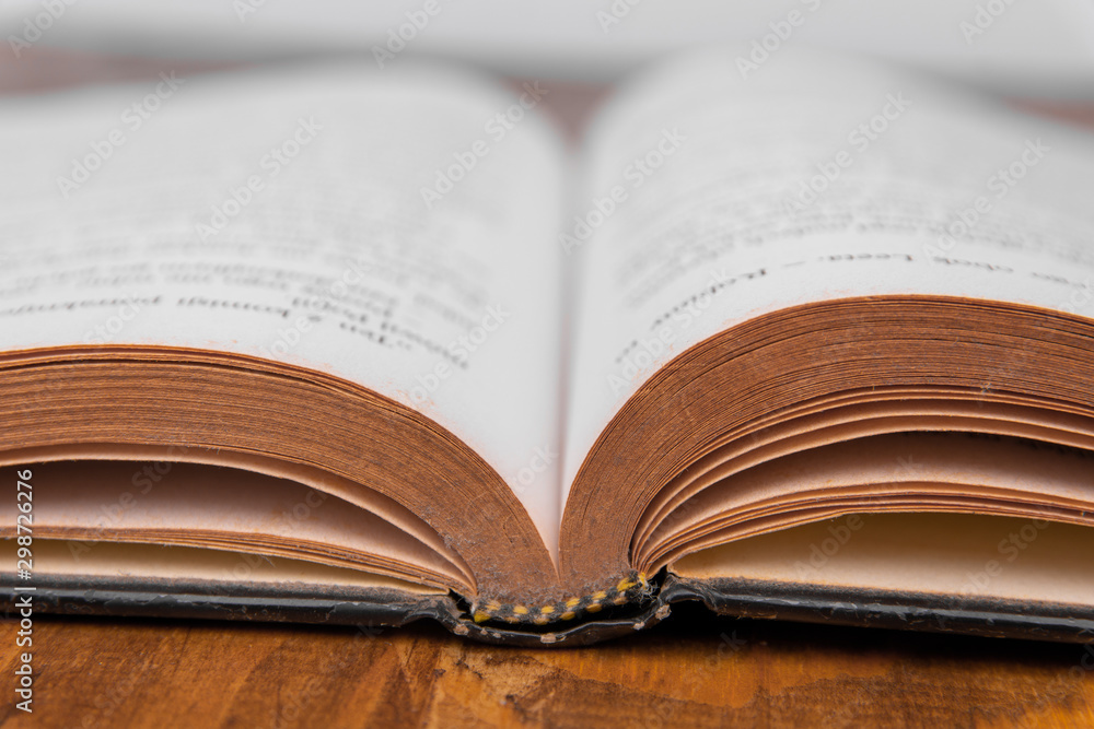 Old open book on a wooden table. White background. closeup Old open book on a wooden table. White background. closeup