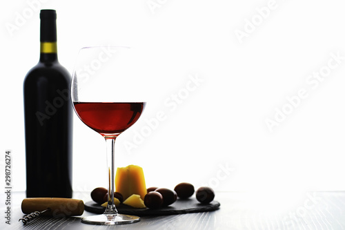 Fototapeta Naklejka Na Ścianę i Meble -  A glass of red dry wine on the table. Dark bottle and glass of wine.