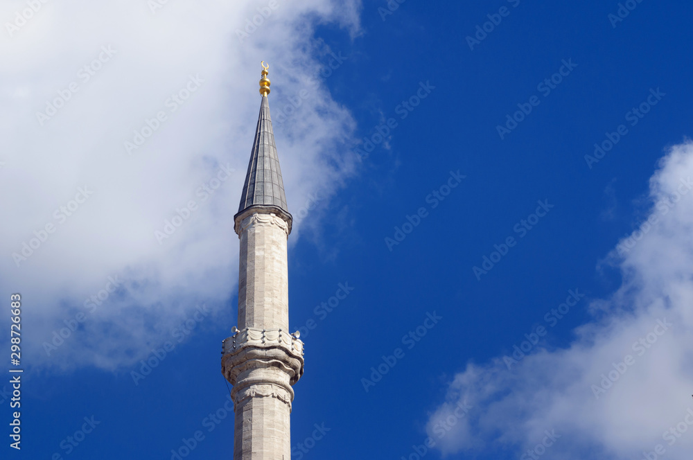 The minaret of the Fatih mosque on the blue sky background.