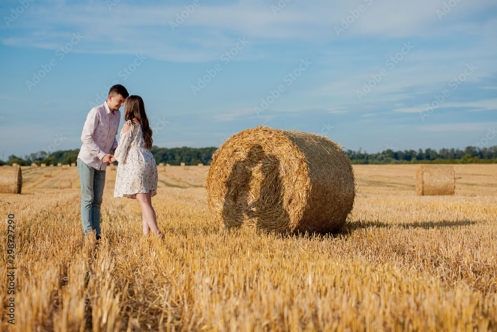 Happy young couple on straw, romantic people concept, beautiful landscape, summer season Happy young couple on straw, romantic people concept, beautiful landscape, summer season