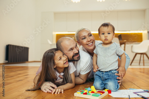 Positive family happy together on floor. Portrait of caucasian family lying, smiling. Happy family concept