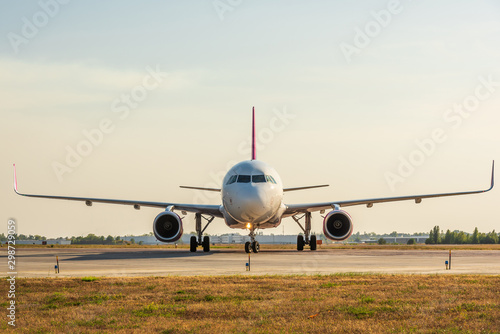 Airplane on airport runway, front view. Travel and transportation concept