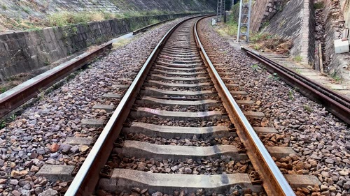 4K - The bending Railway line is carried over gravel and concrete sleepers, slow motion to  a railway tunnel. Source from  60 FPS footage.