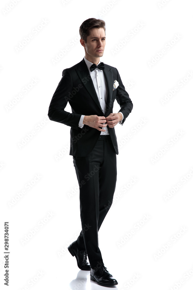 confident young man walking and arranging coat confident young man walking and arranging coat