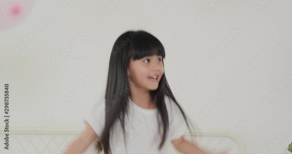 Little girl playing balloon at bedroom with funny emotion. Little girl playing balloon at bedroom with funny emotion.