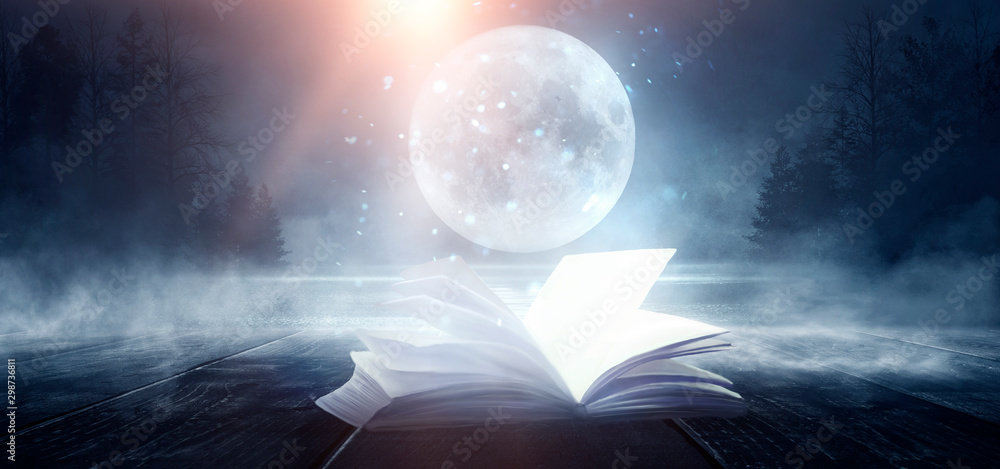 Open magic book with magic lights on a black background, Stock image