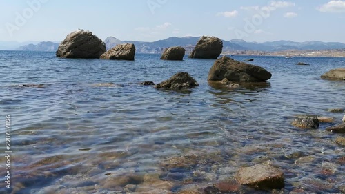 Stone beach, waves and big stones in the sea. 4K realtime video
