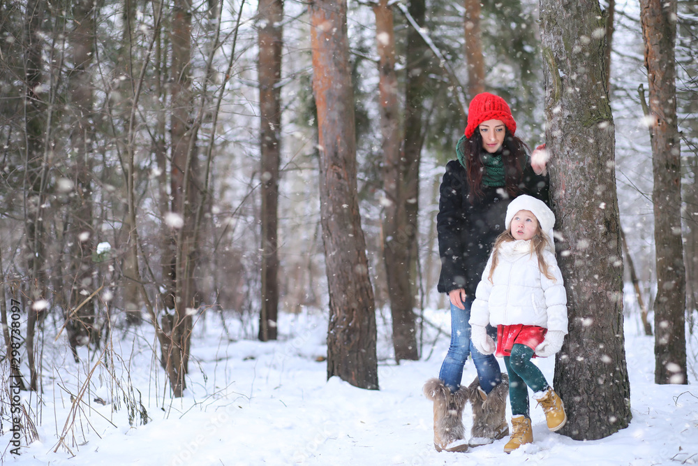 A winter fairy tale in the forest. A girl on a sled with gifts on the eve of the new year in the park. Two sisters walk in a New Year's park and ride a sled with gifts.