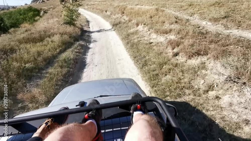 Riding on the roof of a car on a dusty rural road. POV 4K video.