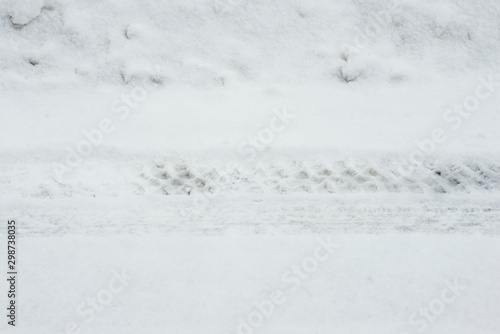 Tire tracks on the snowy ground under blizzard.