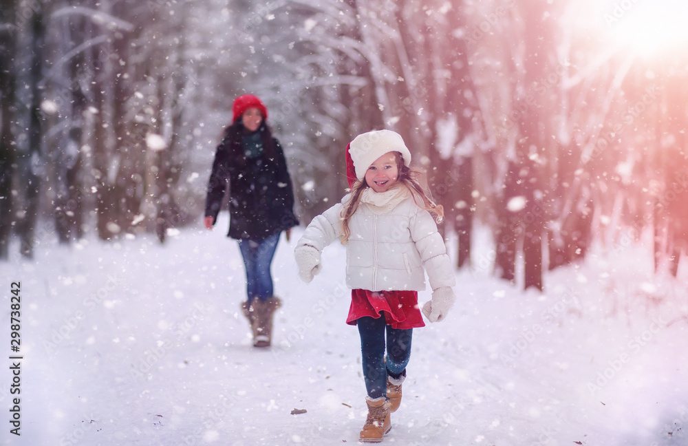 A winter fairy tale in the forest. A girl on a sled with gifts on the eve of the new year in the park. Two sisters walk in a New Year's park and ride a sled with gifts.