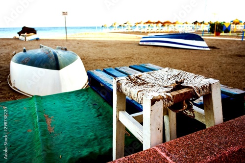 Barcas tradicionales de pesca y banco de enea en una escena costumbrista en la playa de Torremolinos photo