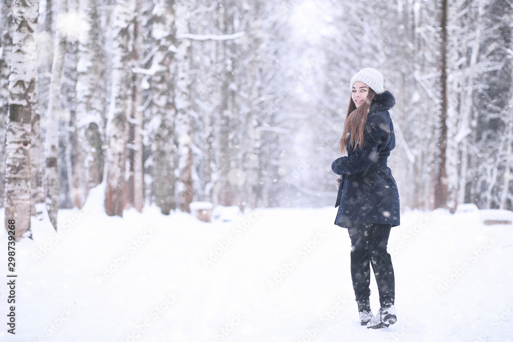 Girl in a winter park in snowfall Girl in a winter park in snowfall