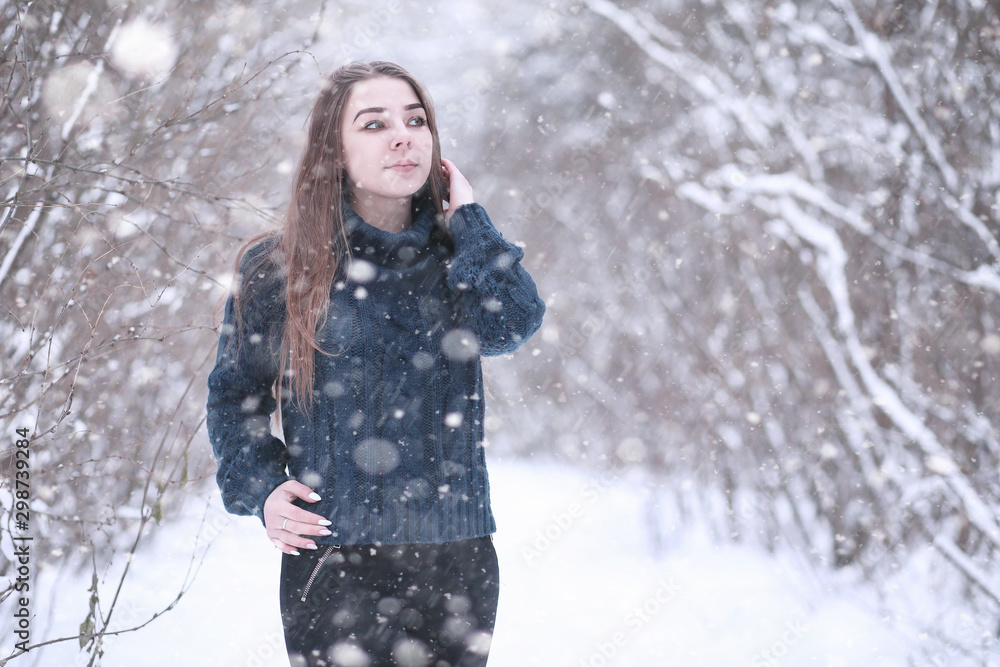 Girl in a winter park in snowfall Girl in a winter park in snowfall
