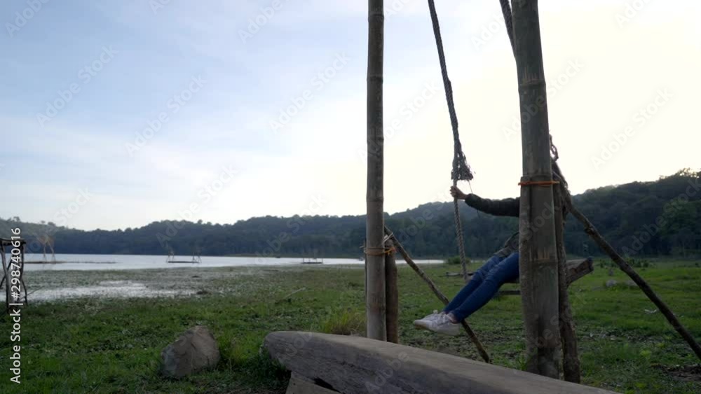 beautiful asian woman swing her self in a countryside. enjoy nature beautiful asian woman swing her self in a countryside. enjoy nature