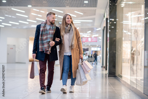 Young casual couple with paperbags looking at clothes in shop window © pressmaster