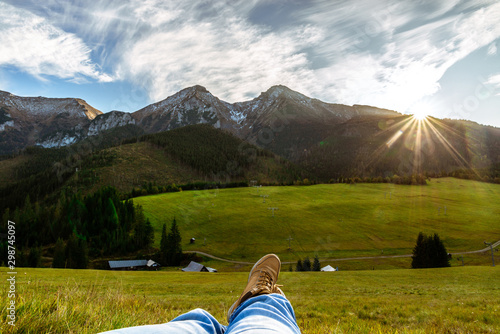 View of legs against the backdrop of rocky mountains in the Tatra Mountains. Zdiar in Slovakia, high Bielanske Tatras. Trip to the mountains, climbing, hiking in the mountains. Rest in the mountains. photo