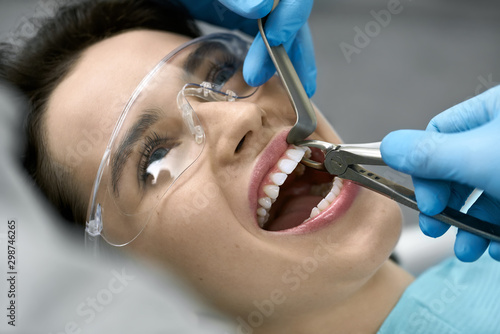 Pretty woman's teeth treatment in dental clinic
