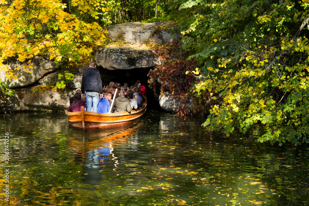 Uman, Ukraine - October 13, 2019: Tunnel, cave under water in the park Sofiyivka Uman. Artificial river excursions in the fall, many beautiful trees Uman, Ukraine - October 13, 2019: Tunnel, cave under water in the park Sofiyivka Uman. Artificial river excursions in the fall, many beautiful trees