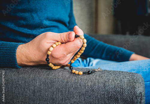 Praying the rosary. The man holds the rosary in his hands saying the prayer. Concept of prayer, religion. Christianity hallmark.