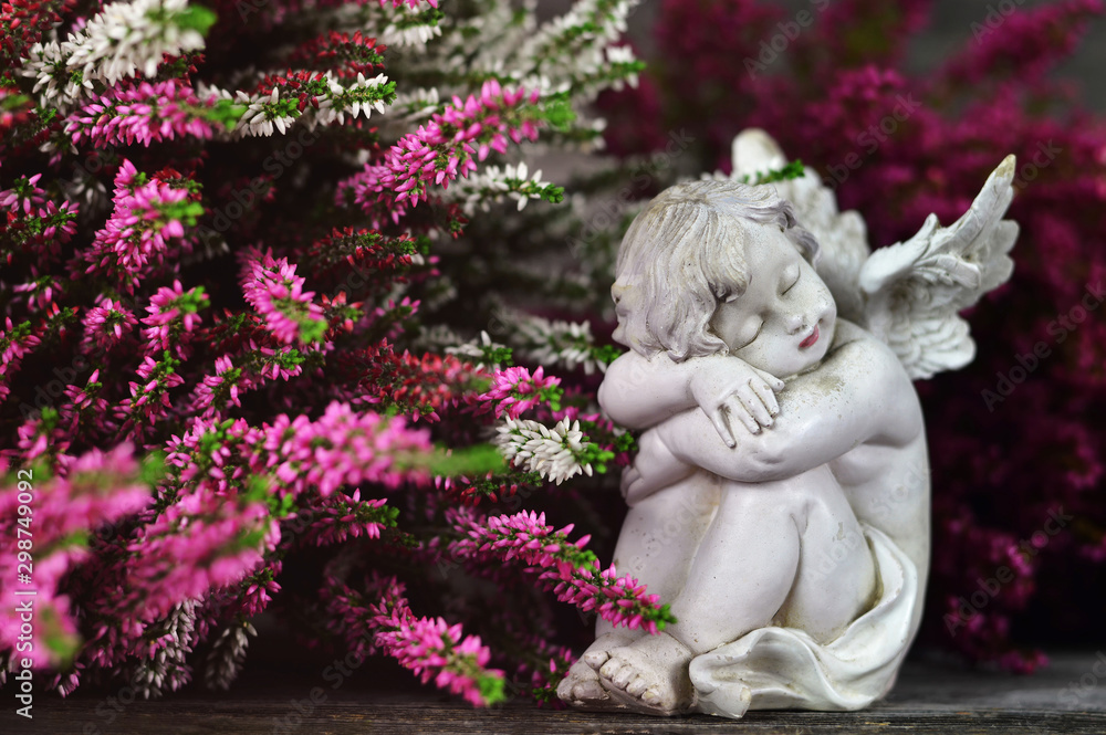 Guardian angel sleeping among heather flowers