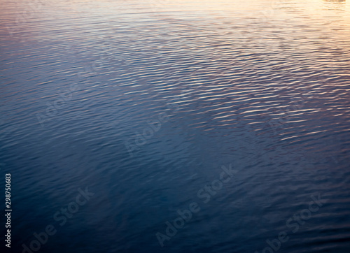 background. waves on the river / sea / ocean in the reflection of sunset / dawn.