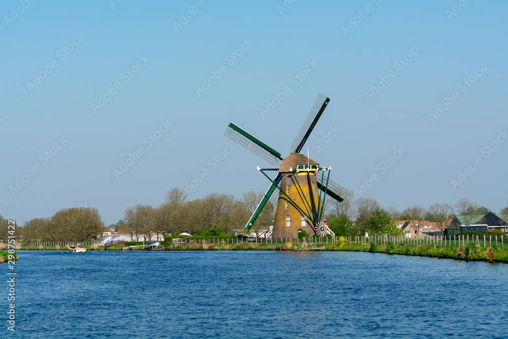 Waterways of North Holland and view on traditional Dutch wind mill, spring landscape
