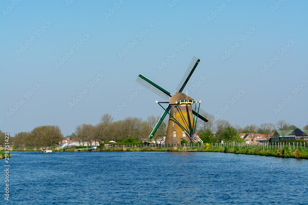 Waterways of North Holland and view on traditional Dutch wind mill, spring landscape Waterways of North Holland and view on traditional Dutch wind mill, spring landscape