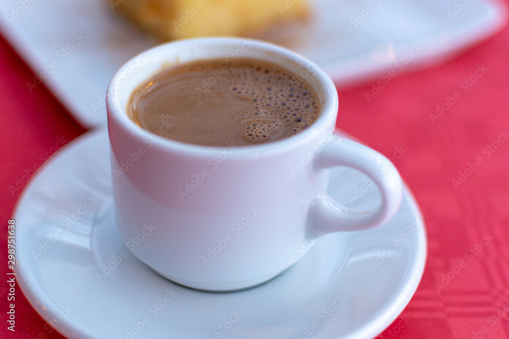 Traditional greek coffee served in white coffee set in cafe