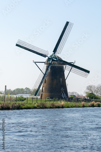 Traditional Dutch wind mill built along the canal in North Holland, spring landscape