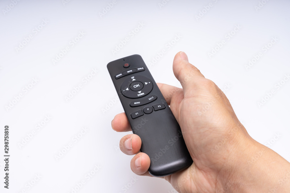  Hand holding a remote control - obrazy, fototapety, plakaty 